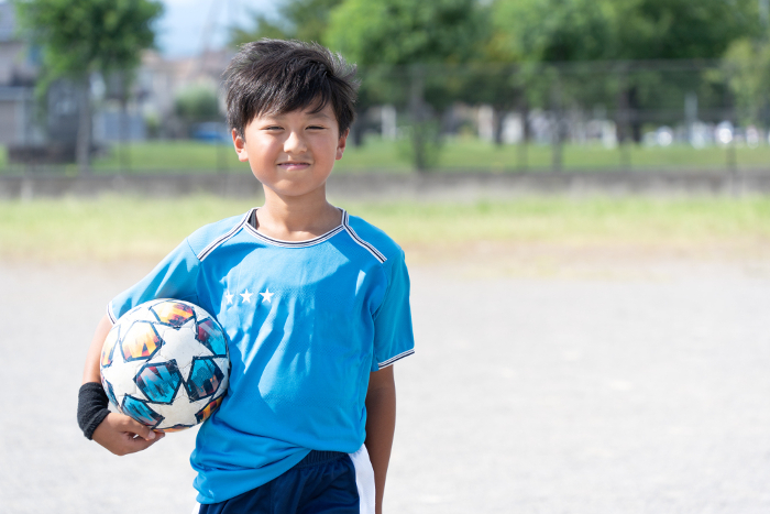Elementary school boy practicing soccer