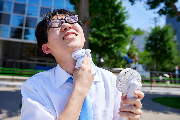 Japanese businessman using a portable fan