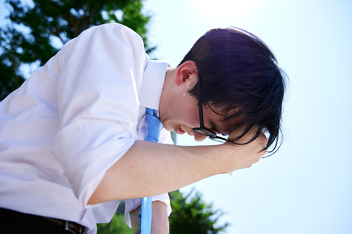 Japanese businessman nodding off in the heat