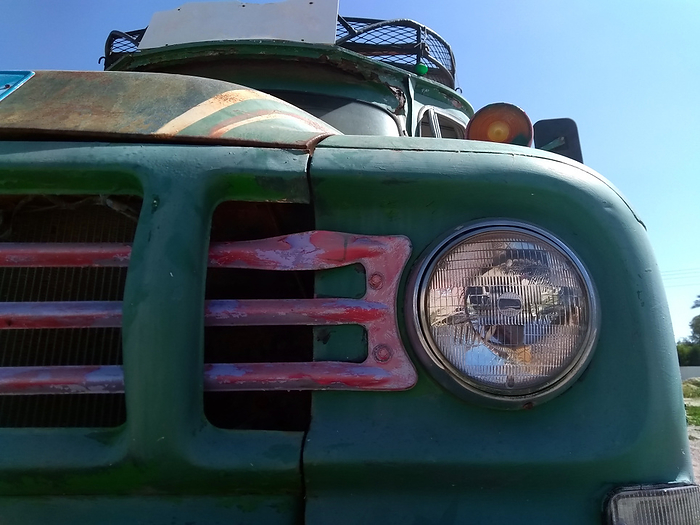front headlamp and grill or an old rusty bus with green hood luggage rack on the roof front headlamp and grill or an old rusty bus with green hood luggage rack on the roof