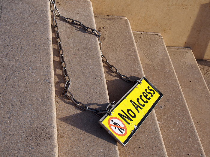 yellow metal no access sign on a chain on concrete steps with no pedestrian symbol yellow metal no access sign on a chain on concrete steps with no pedestrian symbol