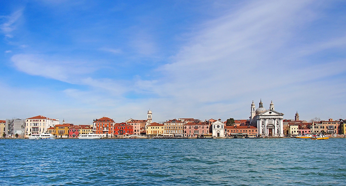 a long seafront panoramic cityscape view of the salute area of venice with historic buildings along the waterfront and a bright blue sunlit sky a long seafront panoramic cityscape view of the salute area of venice with historic buildings along the waterfront and a bright blue sunlit sky
