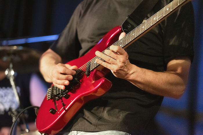 Man lead guitarist playing electrical guitar on concert stage. Man lead guitarist playing electrical guitar on concert stage.