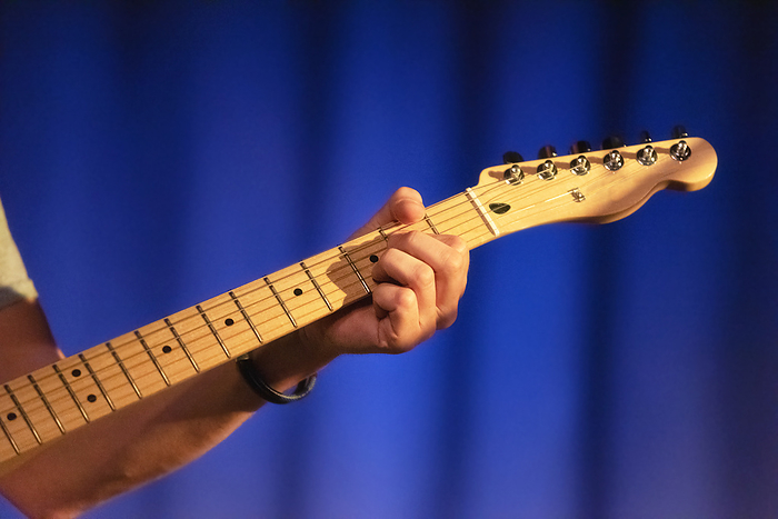 Male hands playing on electric guitar, close up. Male hands playing on electric guitar, close up.