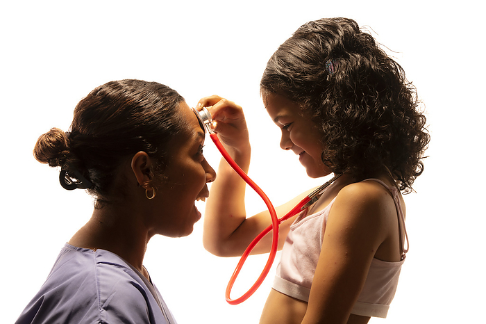 Girl and healthcare professional Young girl playing with a healthcare professional s stethoscope., by SAMUEL ASHFIELD SCIENCE PHOTO LIBRARY