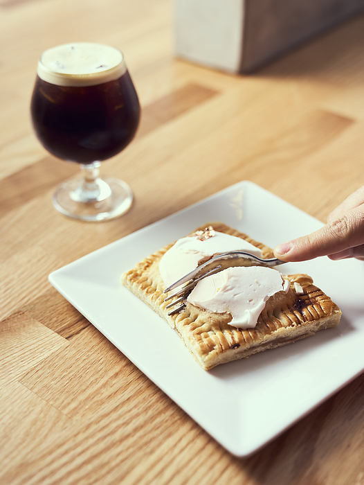 A pop tart pastry being cut and served with nitro cold brew.