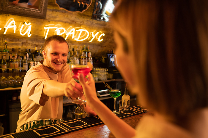Barman serving cocktail to woman