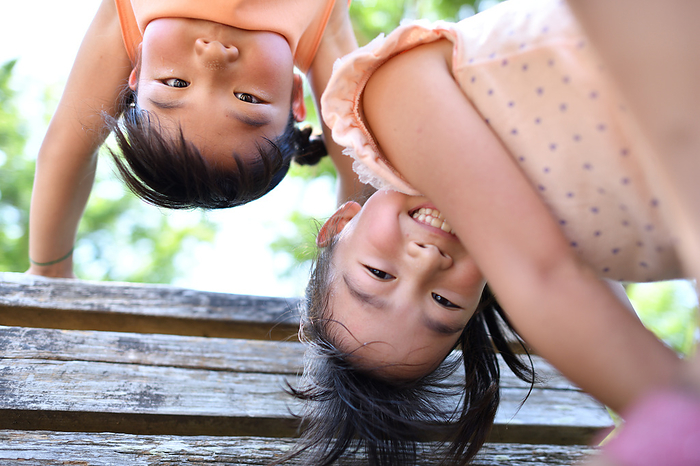 Two girls fooling around on a bench