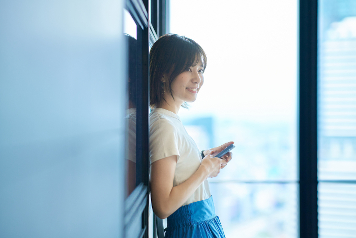 Young Japanese woman holding a smartphone (People)