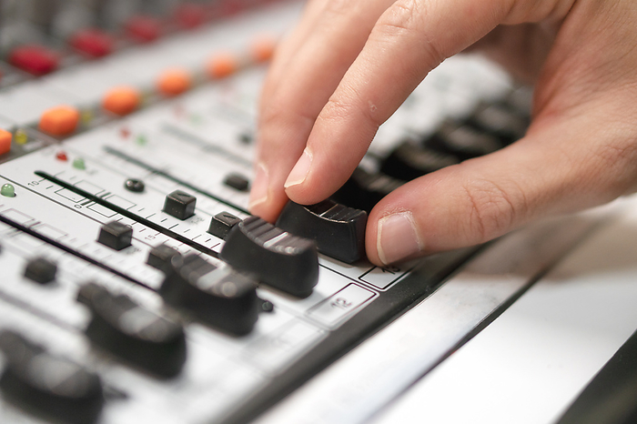 Male hand on control Fader on console. Sound recording studio mixing desk with engineer or music producer. Male hand on control Fader on console. Sound recording studio mixing desk with engineer or music producer.
