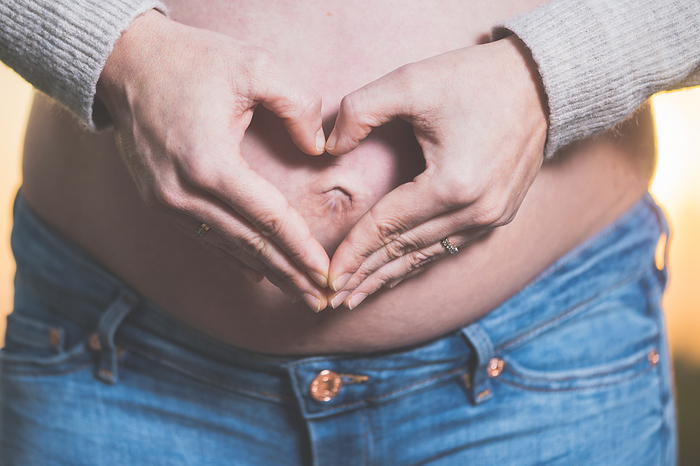 Pregnant woman hands making heart shape on belly. Pregnant woman hands making heart shape on belly.