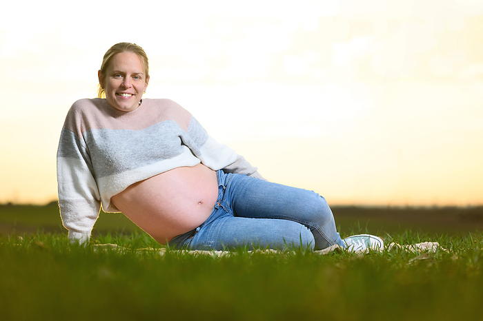 Beautiful pregnant woman lying on the park at sunset. Outdoors pregnant portrait. Beautiful pregnant woman lying on the park at sunset. Outdoors pregnant portrait.