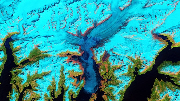 Columbia Glacier, Alaska, 2011 Columbia Glacier, Alaska. False colour satellite image of the Columbia Glacier, Alaska, USA, taken in 2011. Columbia Glacier descends from an ice field  top  3,050 metres above sea level, down the flanks of the Chugach Mountains, and into a narrow inlet that leads into Prince William Sound  bottom centre  in southeastern Alaska. It is one of the most rapidly changing glaciers in the world. Snow and ice appears bright cyan, vegetation is green, clouds are white or light orange, and the open ocean is dark blue. Exposed bedrock is brown, while rocky debris on the glacier s surface is gray. Between 1980 and 2011 the glacier had retreated 20 kilometres north and lost roughly half its thickness and volume. Imaged by NASA s Landsat satellites, on 30th May