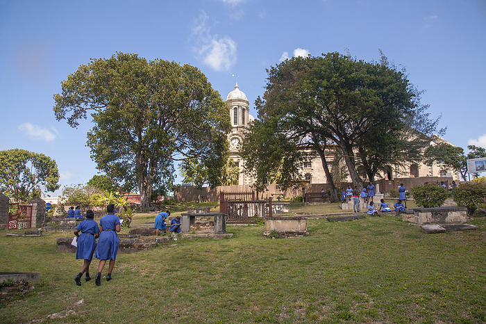 School girls in blue school uniforms during recess in a cemetery; St. John's, Antigua, Antigua and Barabuda, by Matt Propert / Design Pics