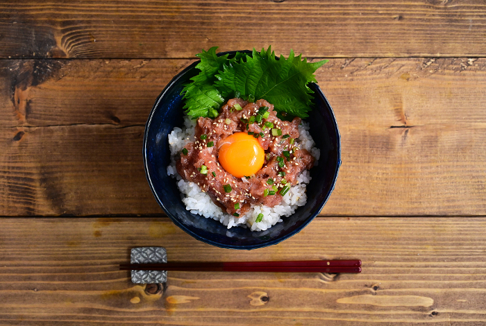 bowl of rice topped with pickled negitoro (onion and tuna)