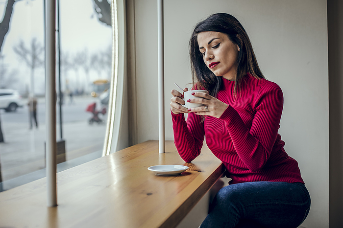Brunette woman drinking coffee in a coffee shop