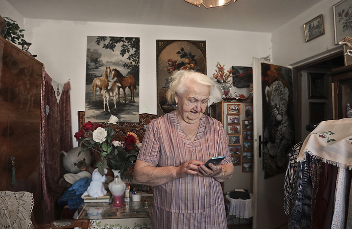 elderly lady uses smartphone at home