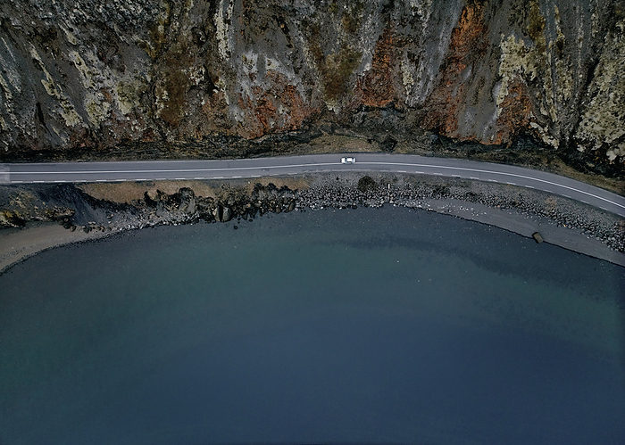 Blue lake with rocky cliff from drone