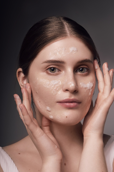 Face skin care. Woman applying a mask on clean hydrated skin portrait. Face skin care. Woman applying a mask on clean hydrated skin portrait.