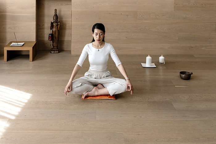 Asian woman exercising and sitting in yoga lotus position