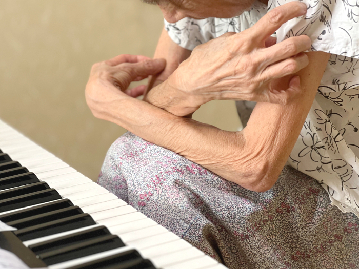 Elderly woman crosses her arms in confusion in front of the keyboard