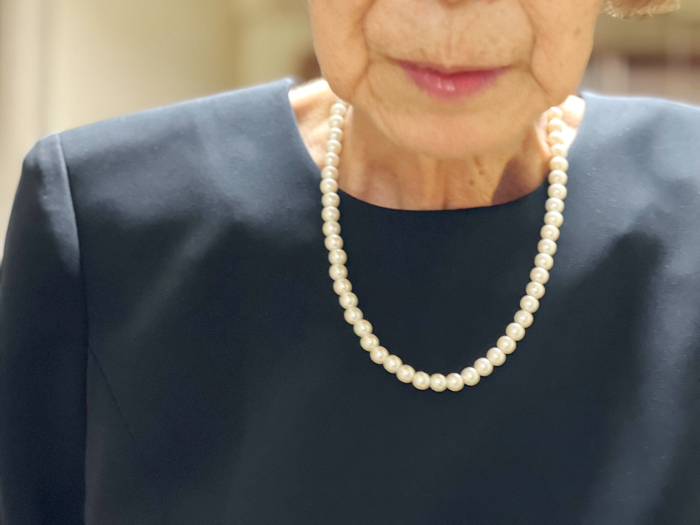 Elderly woman in mourning dress with pearl necklace
