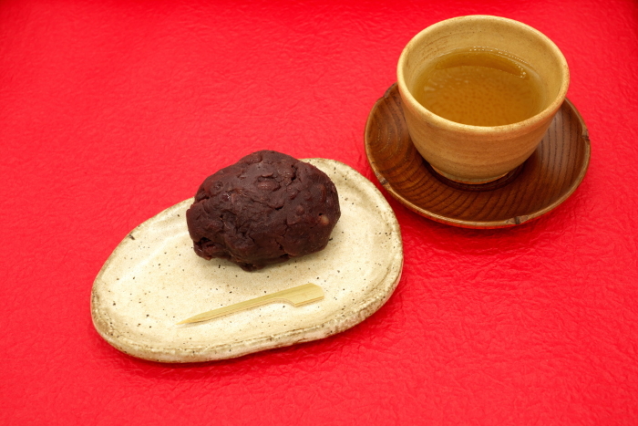 Ohagi and green tea on red Japanese paper background