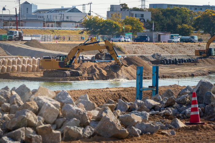 Hydraulic excavator digging for earth at a riverside construction site