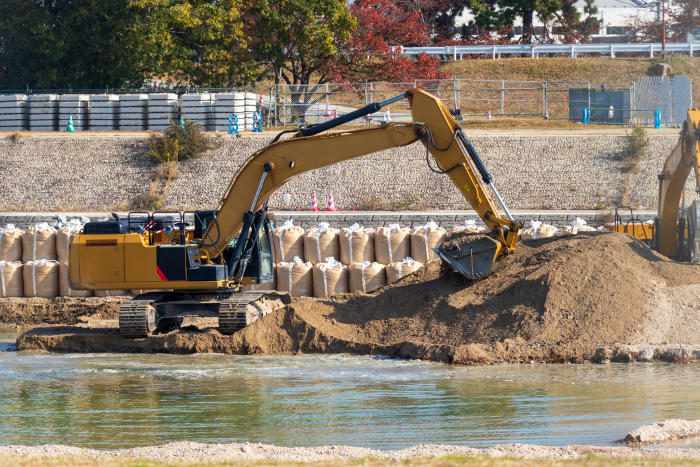 Hydraulic excavator digging for earth on riverbank