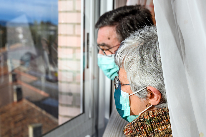senior couple, with protective face masks, at home looking through the window. Concept of coronavirus quarantine stay home and social distancing. Lockdown people. elderly and retired lifestyle. Senior Couple, with Protective Face Mask, at Home Looking Through the Window. Concept of Coronavirus Quarantine Stay Home and Social Distancing. Lockdown People. Elderly and Retired Lifestyle., by Zoonar DAVID HERRAEZ