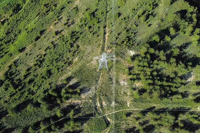Power lines in the forest. Electric tower line in forest Landscape. Ariel view High voltage power pylons. Power Lines in the Forest. Electric Tower Line in Forest Landscape. Ariel View High Voltage Power Pylons., by Zoonar DAVID HERRAEZ