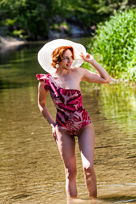 Red haired woman standing in water on the beach Red Haired Woman Standing in Water On The Beach, by Zoonar STphotography