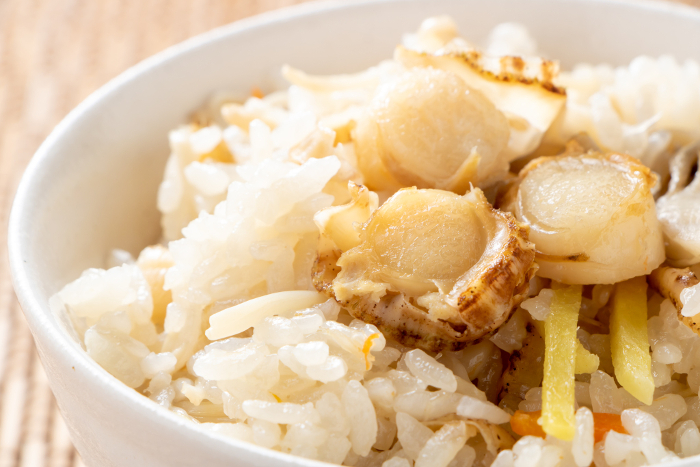 Close-up of rice cooked with baby scallops and mushrooms.