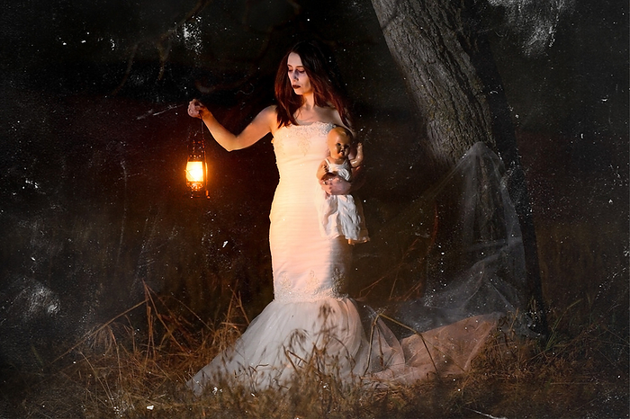 Scary woman with a lantern in night scene   Spooky image of a scary woman with dark eyes and appearance of a witch, in a white dress, holding a lit lantern and a frightening doll, in a dark night atmosphere. Scary Woman with a Lantern in Night Scene   Spooky Image of a Scary Woman Woman Dark Eyes and Appearance of a Witch, in A White Dress, Holding A Lit Lantern and a Frightening Doll, in a Dark Night Atmosphere., by Zoonar DAVID HERRAEZ