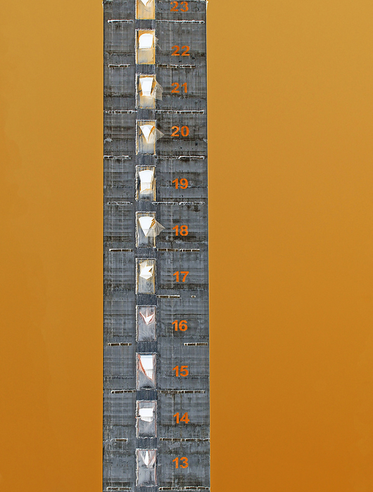 color negative image of a tall concrete tower under construction with building story numbers painted on the levels against an orange background Color Negative Image of a Tall Concrete Tower Under Construction with Building Story Numbers Painted on the Levels Against to Orange Background, by Zoonar PHILIP_OPENSH