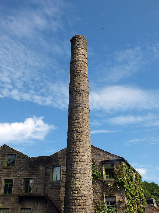 old mill building and tall chimney with blue cloudy sky in hebden bridge west yorkshire Old Mill Building and Tall Chimney with Blue Cloudy Sky in Hebden Bridge West Yorkshire, by Zoonar Philip Opensh