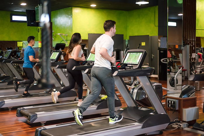 Group of people running on treadmills in modern sport gym. Group of People Running on Treatmills in Modern Sport Gym., by Zoonar DAVID HERRAEZ