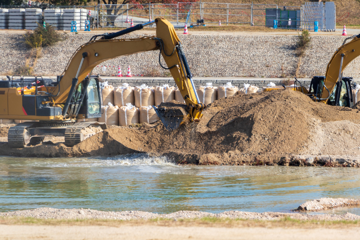 Hydraulic excavator digging for earth on riverbank