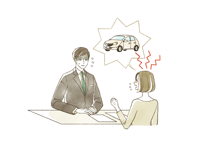 Woman making a complaint about an automobile to a man in a suit.