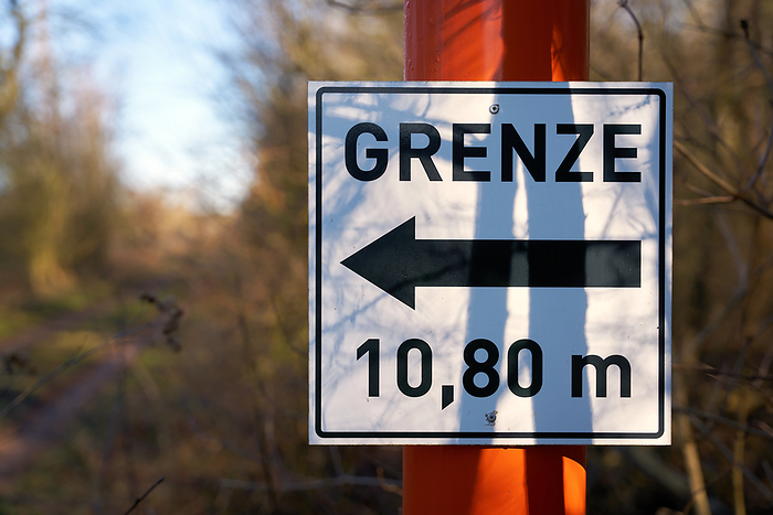 Sign with direction arrow and inscription border 10,80 meters at a forest road in Germany Sign with Direction Arrow and Inscription Border 10.80 meters at a Forest Road in Germany, by Zoonar HEIKO KUEVERL