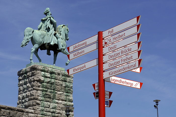 Signpost on the Rhine boulevard, behind it the equestrian statue of Kaiser Wilhelm I at the Hohenzollern bridge Signpost on the Rhine boulevard, behind it the equestrian statue of Kaiser Wilhelm I at the Hohenzollern bridge