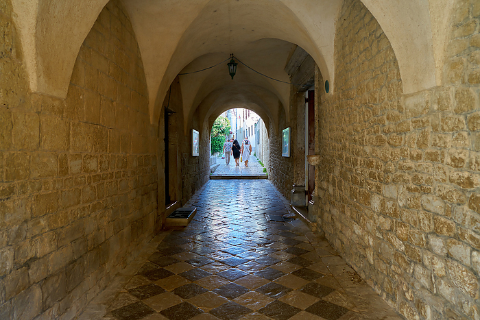 Tourists at a passage at the Cathedral of St. Quirinus in the old town of Krk in Croatia Tourists at a passage at the Cathedral of St. Quirinus in the old town of Krk in Croatia, by Zoonar HEIKO KUEVERL