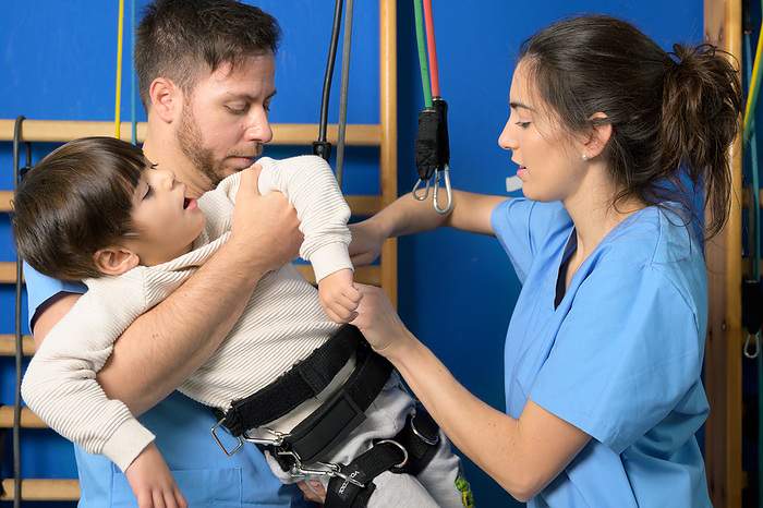Physiotherapists Preparing a children with disability for rehabilitation treatment in hospital. Physiotherapists Preparing a children with disability for rehabilitation treatment in hospital., by Zoonar DAVID HERRAEZ