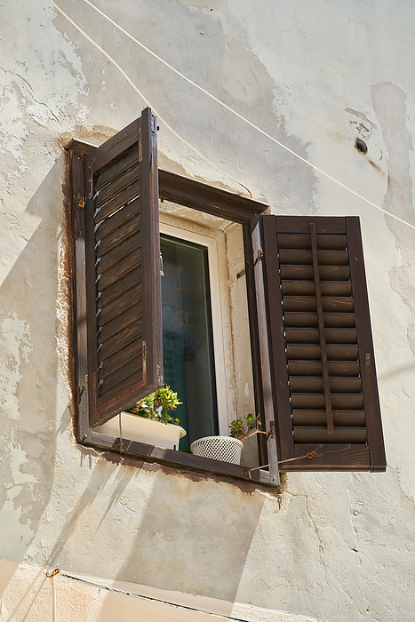 Window with shutter on the facade of a historic house in the old town of Rab in Croatia Window with shutter on the facade of a historic house in the old town of Rab in Croatia, by Zoonar Heiko Kueverl