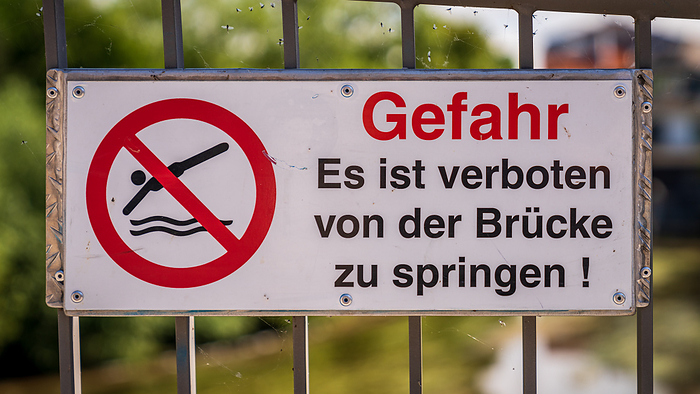 Sign: Danger, Jumping from the bridge is forbidden  in German  Sign: Danger, Jumping from the bridge is forbidden  in German , by Zoonar Bernd Bruegge