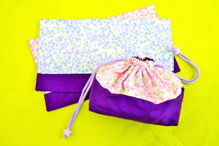 Handmade pink and purple mimosa floral print lunch drawstring and regulation sized chunky mat on yellow-green carpet