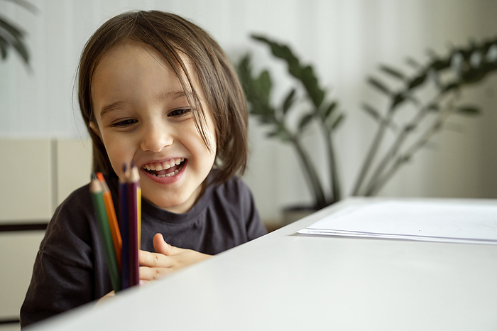 Happy boy looking at colored pencils