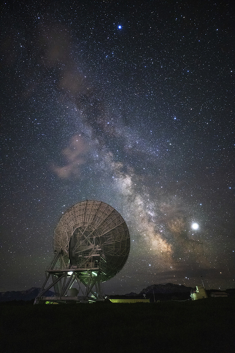 Milky Way above Nanshan observatory, Xinjiang, China Milky Way  centre right  and Jupiter  lower right  shining above a radio telescope in the Nanshan observatory in Xinjiang, China. The Milky Way is our galaxy seen from the inside. It appears as a hazy band of stars and nebulae stretching across the sky. Jupiter is the largest planet in the solar system. It makes a complete orbit around the Sun in 12 Earth years. Photographed on 1 June 2019., by JEFF DAI   SCIENCE PHOTO LIBRARY