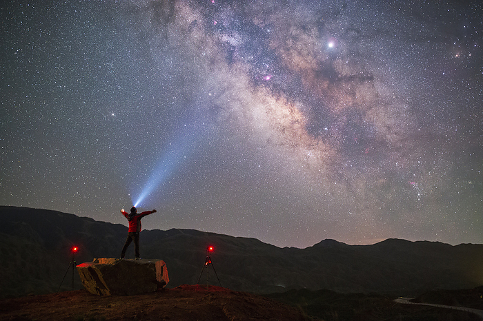 Stargazer looking towards sky, Gansu, China Stargazer looking towards the southern sky in Gansu, China. The band of the Milky Way  upper centre to lower right  and Jupiter  upper right  shine brightly in the sky. Photographed on 11 May 2019., by JEFF DAI   SCIENCE PHOTO LIBRARY