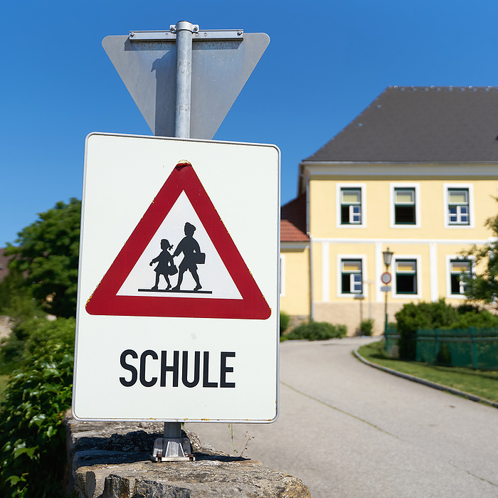 Danger sign indicating possible school children in the road area in Emmersdorf in Austria Danger sign indicating possible school children in the road area in Emmersdorf in Austria, by Zoonar Heiko Kueverl